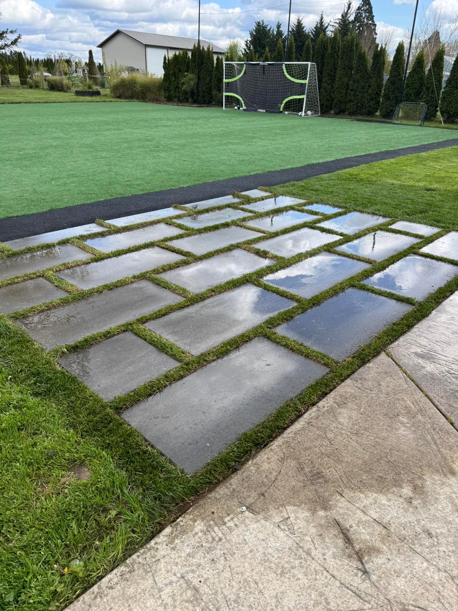 Modern stepping-stone pavers set into artificial turf — designed by GI Landscape