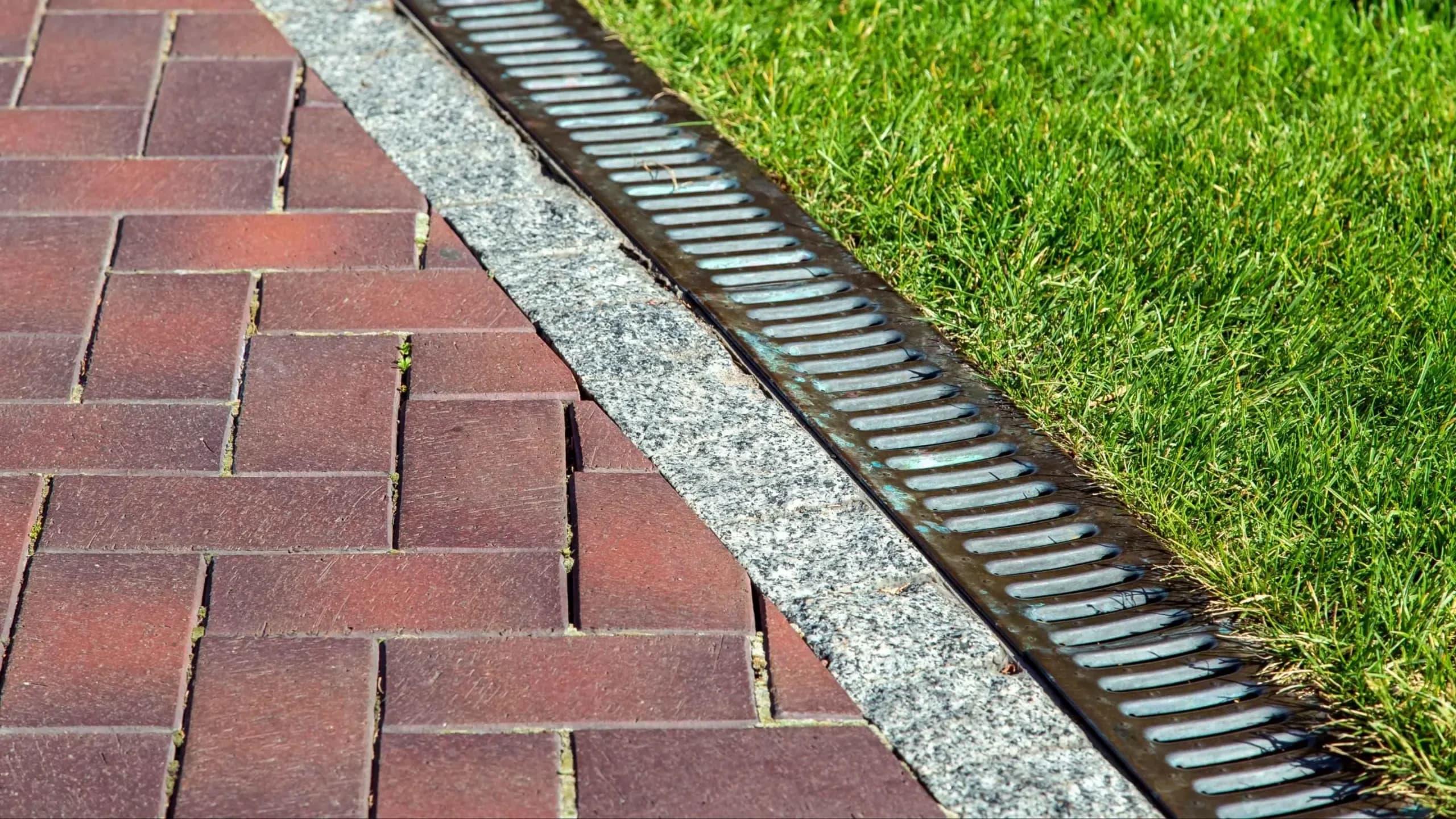 French drain installation by GI Landscape — perforated pipe in drainage rock, geotextile-wrapped