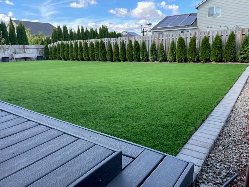 Garden sprayer ready to clean a section of artificial turf installed by GI Landscape