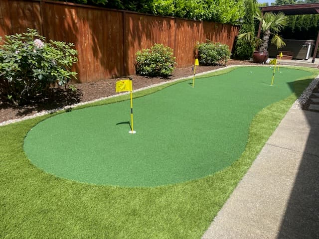 Bare feet on a cool, green artificial turf install in summer